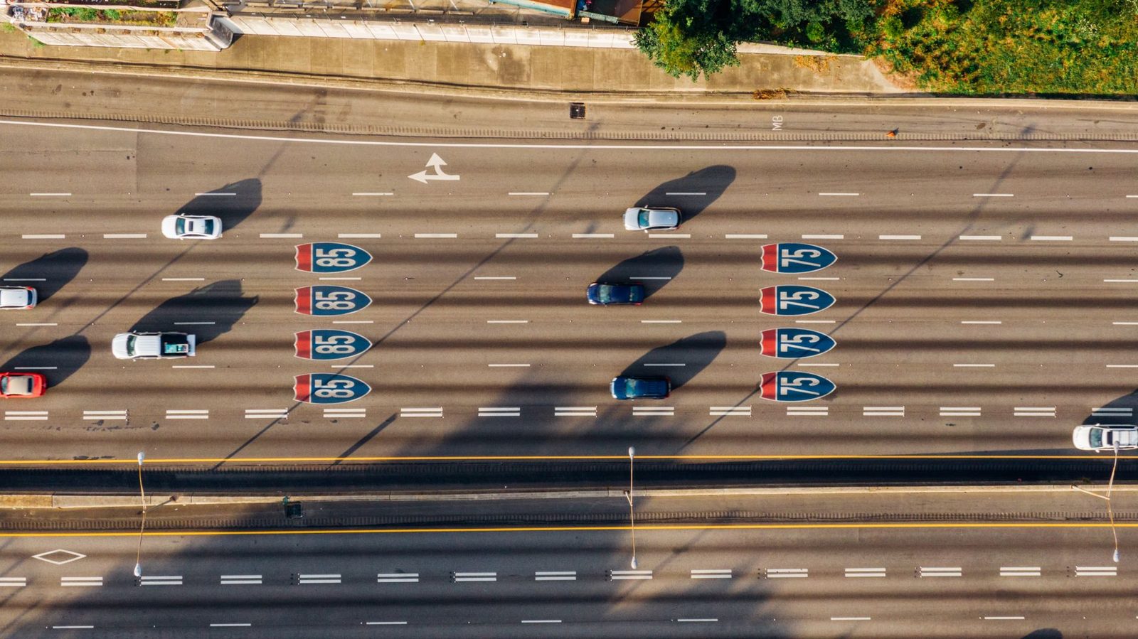 Aerial view of traffic on Atlanta's I-75 and I-85 highways on a sunny day.