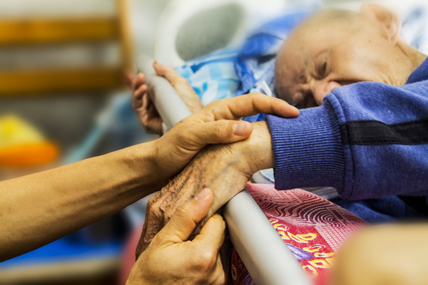 Holding hand of an elderly family member.