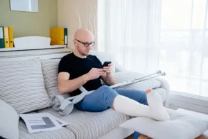 A person with their leg in a cast, sitting on a couch.