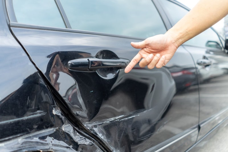 Damaged Car Hand Pointing at Damaged Car