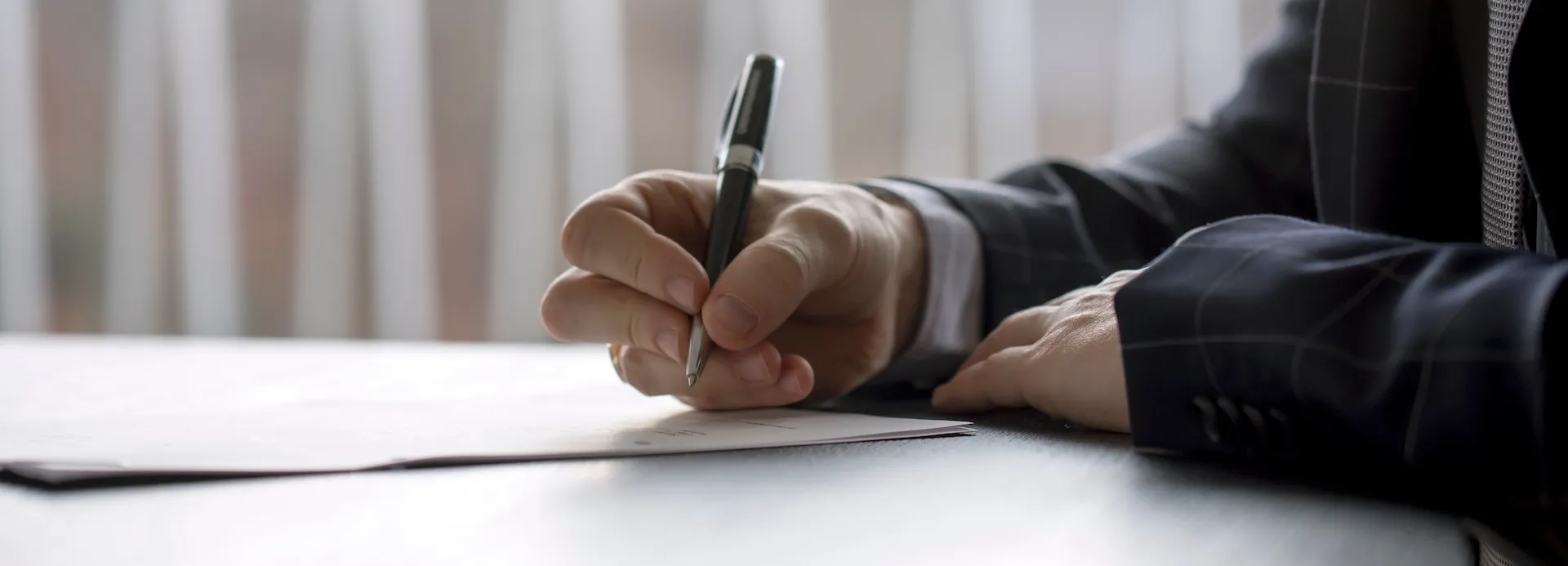 Man signing a document in a law office-img