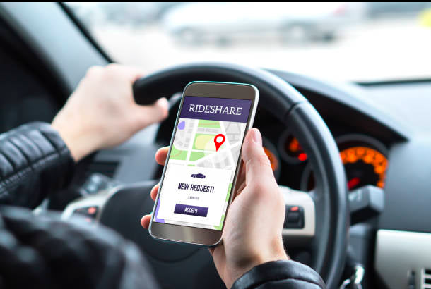 A person interacting with a rideshare app on a smartphone.