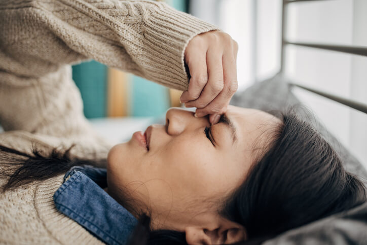 woman lying down with headache concussion symptoms