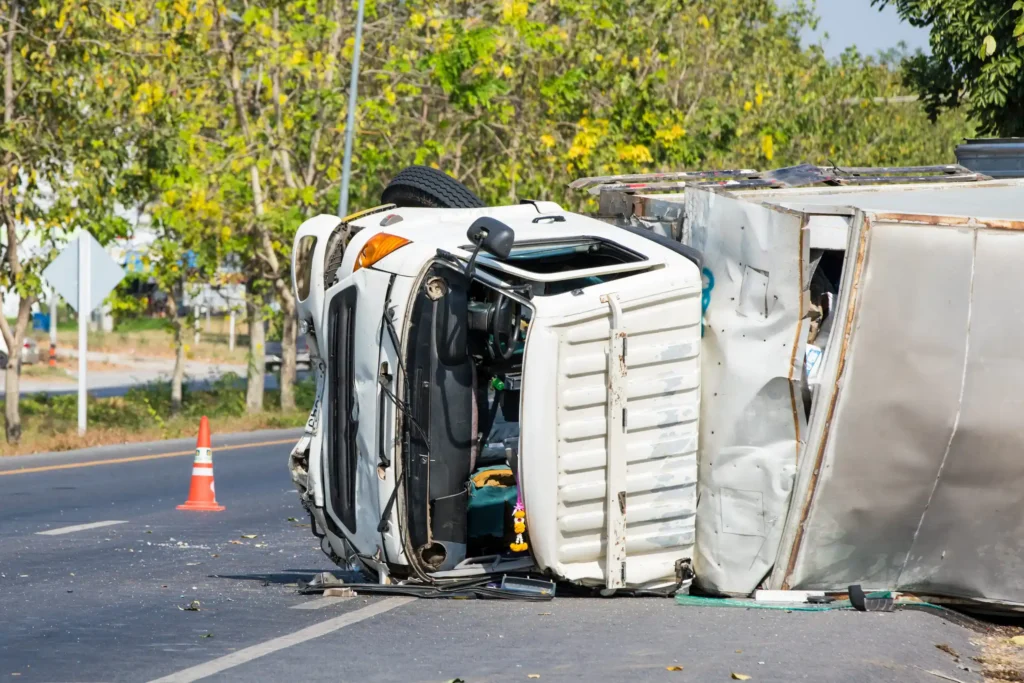 Crash scene: Damaged car off the side of a highway after a collision with a tractor-trailer